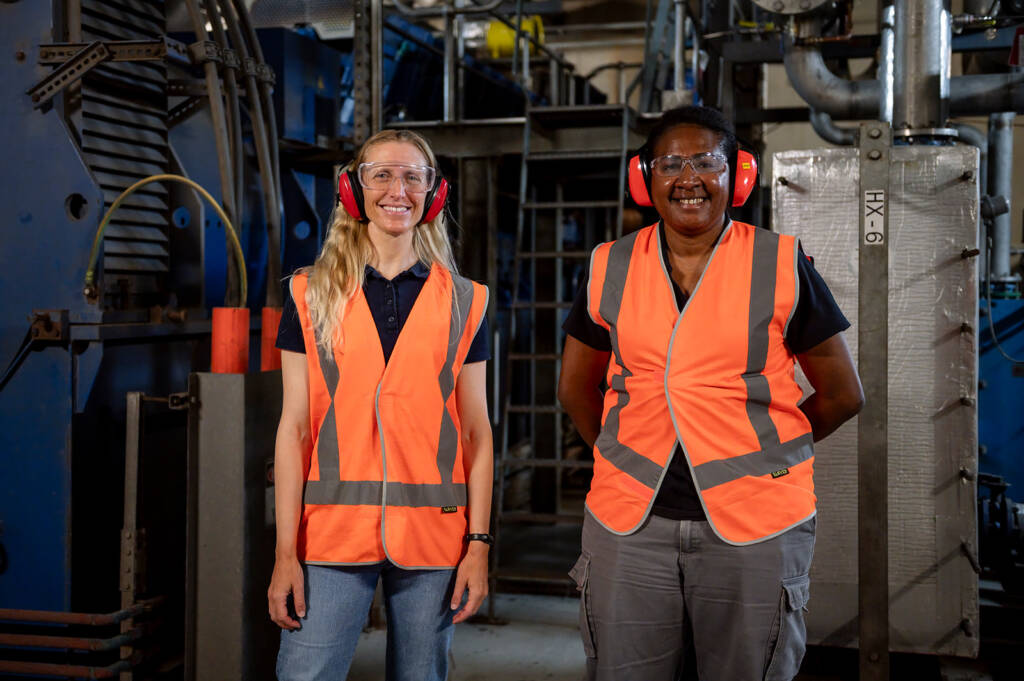 Two women in high vis and ear protection