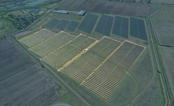 Aerial view of solar farm surrounded by green fields